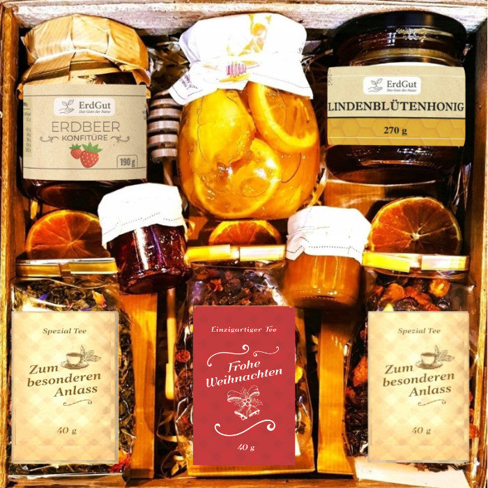 Geschenkkorb mit Honig Tee Schokolade Konfitüre Sirup und Nüssen im dekorativen Korb