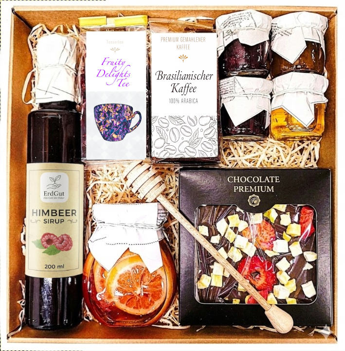 Geschenkkorb mit Tee Honig Schokolade Sirup Zitrone und Kaffee im dekorativen Korb voller Genuss