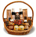 Geschenkkorb mit Honig Tee handgemachter Schokolade Konfitüre Sirup und weiteren Delikatessen im Korb.