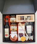 Geschenkkorb mit Honig Tee Schokolade Konfitüre Sirup handverlesene Delikatessen im dekorativen Korb