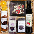 Geschenkkorb mit Honig Tee Schokolade Konfitüre Nüsse und Sirup im dekorativen Korb