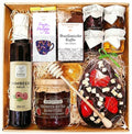 Geschenkkorb mit Honig Tee Schokolade Konfitüre Sirup handverlesene Delikatessen im dekorativen Korb