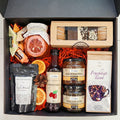 Geschenkkorb mit Honig Tee Schokolade Konfitüre Nüsse Sirup handverlesene Delikatessen im Korb