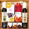 Geschenkkorb mit Honig Tee Schokolade Konfitüre Sirup Nüssen im dekorativen Genusskorb
