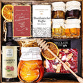Geschenkkorb mit Honig Tee Schokolade Konfitüre Sirup Nüssen im dekorativen Korb voller Genuss