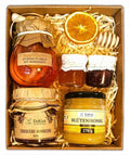Geschenkkorb mit Honig Tee Schokolade Konfitüre Sirup Nüssen im dekorativen Korb voller Genuss