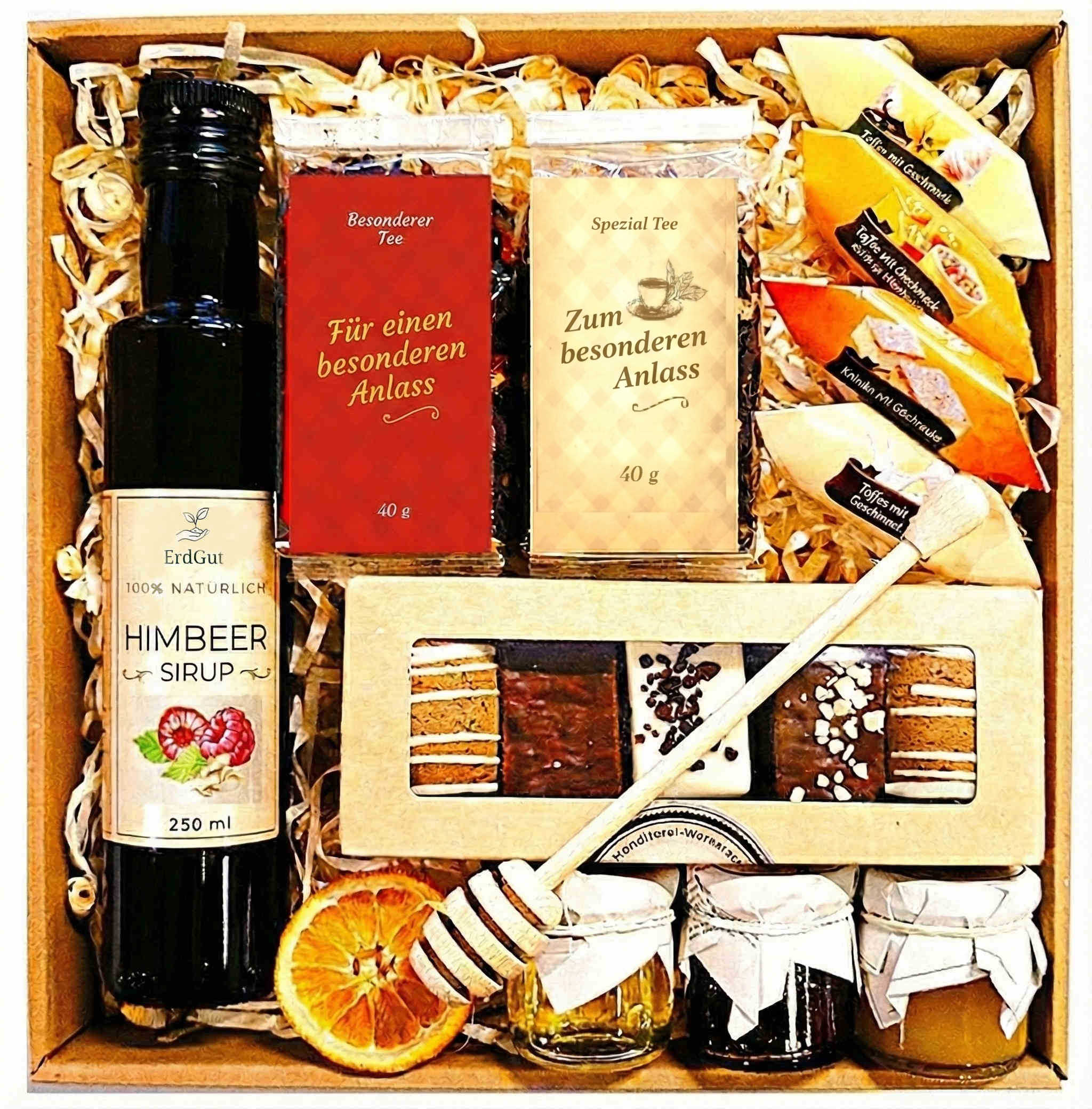 Geschenkkorb mit Honig Tee Schokolade Konfitüre Nüssen Sirup im dekorativen Genusskorb