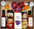 Geschenkkorb mit Honig Tee Schokolade Konfitüre Sirup Nüssen im dekorativen Korb voller Genuss
